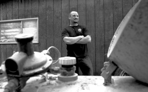 Chris standing at propane tank on side of garage
